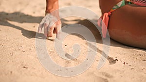 Young Woman in Bikini Swimsuit Drawing Heart on White Sand at Tropical Island Beach in Thailand. 4K, Slowmotion.
