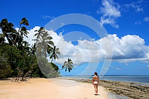 Young woman in bikini walking on the beach at Makaha`a island ne photo