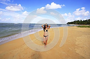 Young woman in bikini walking on Las Terrenas beach, Samana peninsula photo