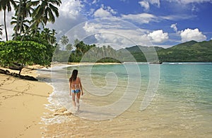 Young woman in bikini walking at Rincon beach, Samana peninsula photo
