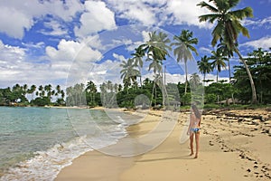 Young woman in bikini walking at Rincon beach, Samana peninsula