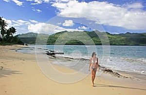 Young woman in bikini walking at Rincon beach, Samana peninsula