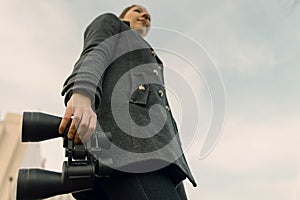 Young woman with binoculars looking forward. Prospects for future business