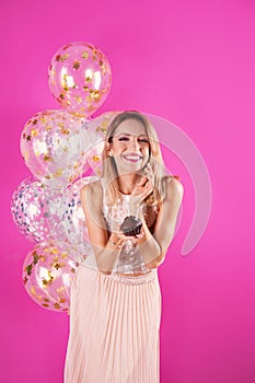 Young woman with birthday muffin and air balloons