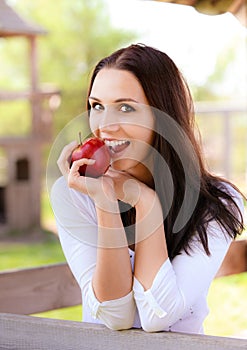 Young woman bites apple