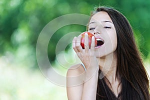 Young woman biting red apple