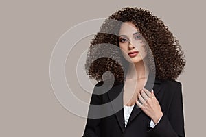 A young woman in a black cape. female hairstyle afro curls. Beauty and fashion portrait