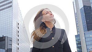 Young woman in black coat walking at the center