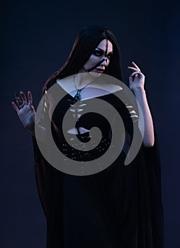 Young woman in black dress in Gothic style