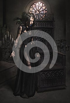 Young woman in black fantasy costume with feathers
