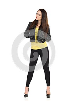 Young Woman In Black Leather Jacket, Leggings And High Heels Is Looking Away