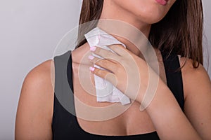 Young woman in black tank top clean neck with wet wipes