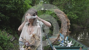 young woman blindfolded. Calm, meditation, retro style. Boat decor on the river bank. Couple in love. Exciting moments