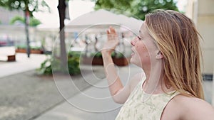 Young woman blogger recording travel vlog walking on summer city street.