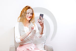 Young woman blogger using mobile phone for interaction video calling. Female talking via messenger app having video chat on mobile