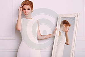 Young woman with blond hair in retro style,wears elegant white dress