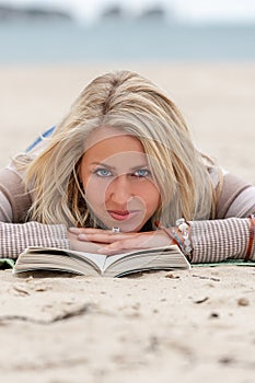 Young Woman Blonde Hair Blue Eyes Reading a Book at the Beach