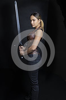 Young woman in urban fantasy poses on a black background photo