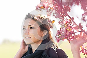 Young woman by blossoming apple tree