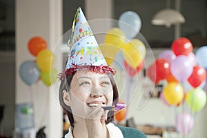 Young Woman Blowing Party Horn