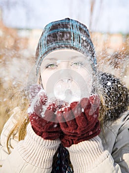 Young woman blowing snow