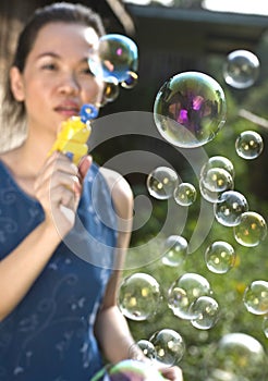 Young woman blowing soap bubbles