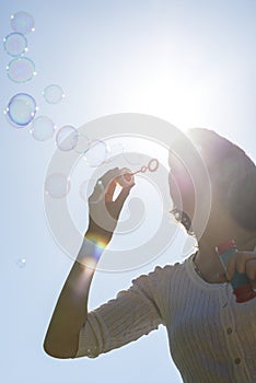 Young woman blowing soap bubbles