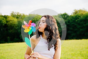 Young woman blowing a windmill