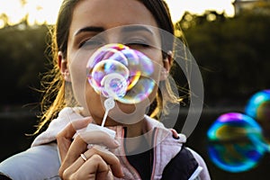 The young woman blows a lot of soap bubbles