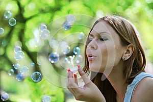 Young woman blows soap bubbles