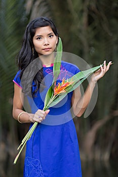 Young Woman in Blue Ao Dai Holding Flowers