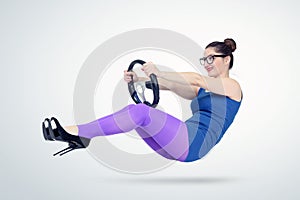 Young woman in blue dress and glasses with a car steering wheel. Lady driver concept