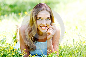 Young woman in blue dress lying on grass