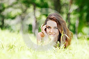 Young woman in blue dress lying on grass