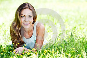 Young woman in blue dress lying on grass