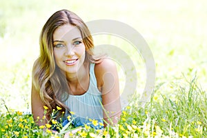 Young woman in blue dress lying on grass