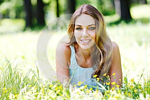 Young woman in blue dress lying on grass