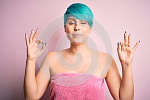 Young woman with blue fashion hair wearing towel after shower over pink background relax and smiling with eyes closed doing