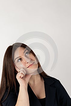 Young woman in blue full of doubts and hesitation. Looking up