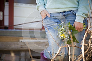 Young woman on blue jeans holding a beautiful garden flowers in her hand. Summer bouquet in girl`s hand. Outdoor. Spring garden p