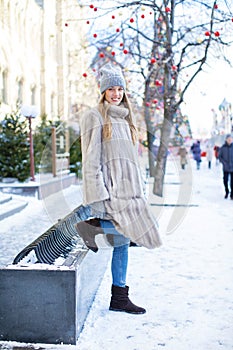 Young woman in a blue knitted hat and gray mink coat