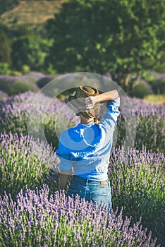 Young woman in blue shirt enjoying lavender field, Isparta, Turkey