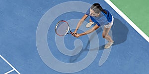 Young woman in blue shirt playing tennis. Youth, flexibility, power and energy.