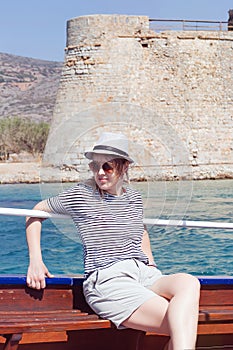 Young woman on a boat traveling to the ancient fortress