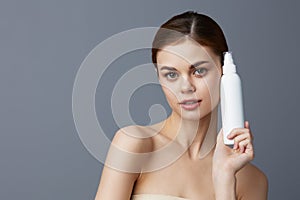 young woman body lotion rejuvenation cosmetics Gray background