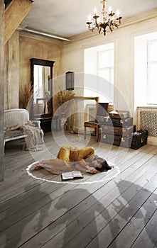 Woman with a book is sleeping on the floor  at home