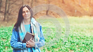 Young woman with book on the walk. Time for reading. Reading book concept