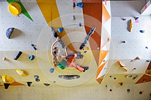 Young woman bouldering in climbing gym