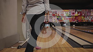 young woman is bowling. Indoors, sports game, heavy balls. Special shoes, rookie. close up