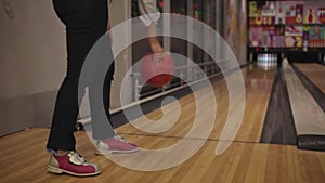 young woman is bowling. Indoors, sports game, heavy balls. Special shoes, rookie. knocks down one pin close up
